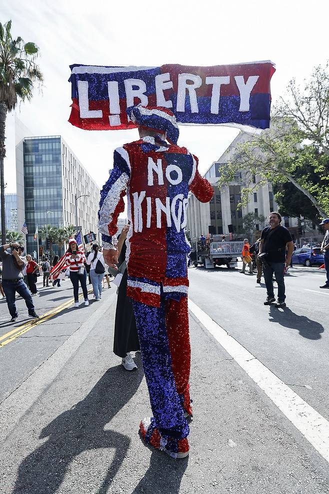 28일(현지시간) 미국 캘리포니아주 로스앤젤레스 도심에서 열린 ‘노킹스(No Kings)’ 집회에서 시위대가 팻말을 들고 행진하고 있다. EAP=연합뉴스