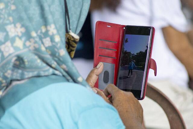 인도네시아 발리 덴파사르의 한 공원에서 시민이 휴대전화를 사용하고 있다. 인도네시아 정부는 온라인 아동 보호 강화를 위해 3월28일부터 16세 미만 미성년자의 소셜미디어 이용을 제한하는 규정을 시행하고 있다. EPA연합통신