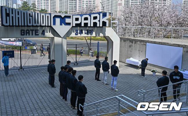 [OSEN=창원, 이석우 기자] 29일 창원NC파크에서 2026 신한 SOL KBO 리그 NC 다이노스와 두산 베어스의 경기가 열린다. NC 다이노스 야구단이 1년전 창원NC파크 외벽 구조물 추락 사망 사고 1주기 추모행사를 열었다. NC 다이노스 이진만 대표, 임선남 단장, 이호준 감독, 박민우와 직원들이 희생자의 명복을 비는 묵념을 하고 있다. 2026.03.29 / foto0307@osen.co.kr