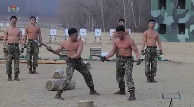 조선중앙TV는 29일 전투원들이 김정은 노동당 총비서 앞에서 진행한 시범 장면을 보도했다. 복부 근육으로 도끼를 튕겨내는 모습. 사진=조선중앙TV 캡처