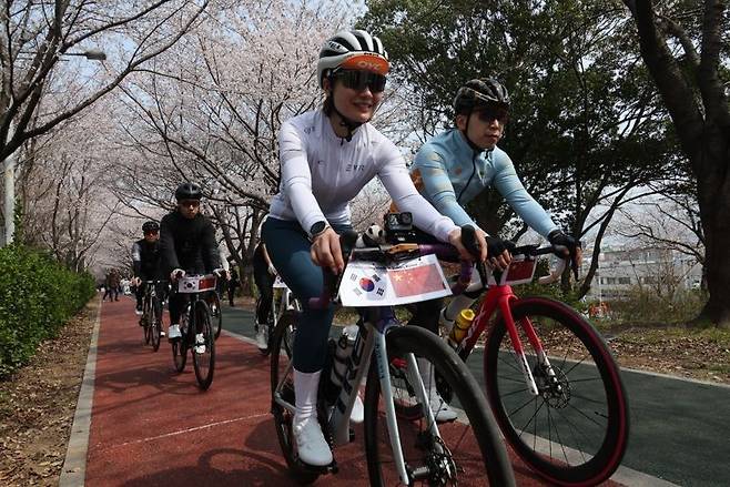"빵지러, 부산" 벚꽃이 활짝 핀 부산의 자전거길에서 중국 라이더들이 페달을 밟으며 여행을 즐기고 있다. ㈜에어바이크 제공