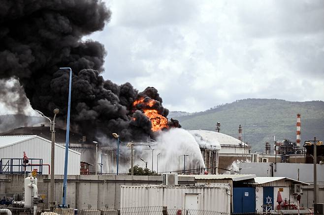30일(현지시각) 이스라엘의 하이파 정유시설에 있는 연료저장고에서 발생한 화재를 소방대원들이 진압하고 있다. 로이터 연합뉴스