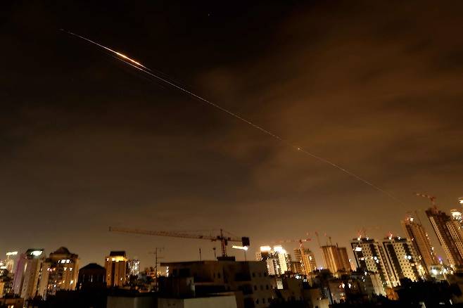 23일(현지시간) 이스라엘 해안 도시 네타냐 상공에 이란의 새로운 미사일 공격으로 인한 로켓 궤적이 하늘을 가르고 있다. AFP=연합뉴스