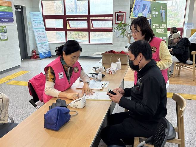외국인 노동자 무료진료 봉사자가 29일 인천 서구 인천기독교종합사회복지관에서 진료 전 등록을 돕고 있다.