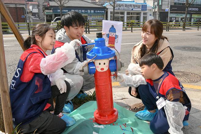 현대모비스 임직원과 가족들이 서울시 도봉구 일대 지상식 소화전 도색 봉사활동을 하고 있는 모습./사진제공=현대모비스
