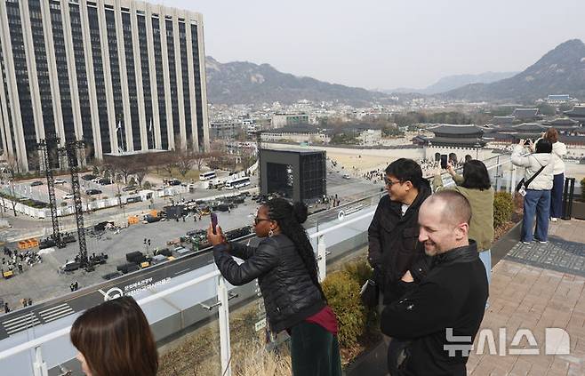 [서울=뉴시스] 김근수 기자 = 22일 오전 서울 종로구 광화문광장에서 전날 열린 방탄소년단의 'BTS 컴백 라이브 : 아리랑' 공연 무대 철거작업이 진행되는 가운데 외국인 관광객들이 사진을 찍고 있다. 2026.03.22. ks@newsis.com