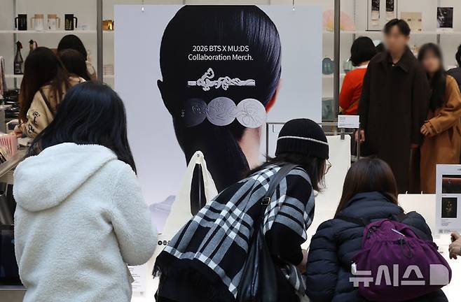 [서울=뉴시스] 배훈식 기자 = 국립박물관재단과 하이브가 협업한 성덕대왕신종 문양을 활용한 '뮷즈' 판매가 시작된 지난 20일 오후 서울 용산구 국립중앙박물관에서 해외 아미(BTS 팬)들이 굿즈를 구입하고 있다. 2026.03.20. dahora83@newsis.com