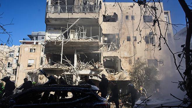 24일 이란 미사일 피해 지역을 확인하는 이스라엘 군인들