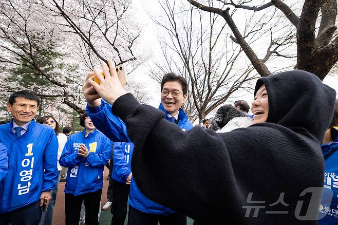 정원오 더불어민주당 서울시장 예비후보가 31일 오전 서울 동대문구 장안동 벚꽃길에서 시민과 셀카를 찍고 있다. (정원오 캠프 제공. 재판매 및 DB 금지) 2026.3.31 ⓒ 뉴스1