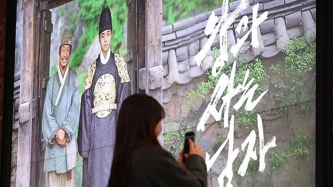 역대 국내 개봉 영화 중 누적 매출 1500억원을 넘긴 유일한 영화 ‘왕과 사는 남자’가 영화 ‘극한직업’을 제치고 관객 수로도 역대 2위에 오를 기세다. 사진은 한 상영관에서 ‘왕사남’ 포스터를 촬영하고 있는 관객. /뉴시스