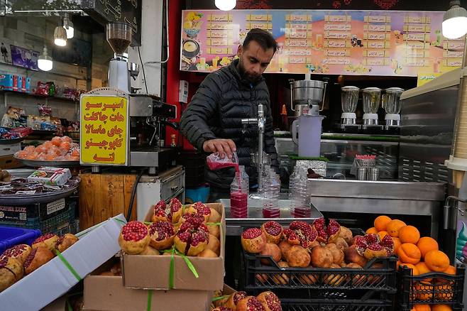29일(현지시간) 이란 테헤란 재래시장에서 상인이 주스를 만들고 있다. 공습에서도 일상을 유지하며 버티는 ‘저항경제’의 한 단면이다. [AP=연합뉴스]