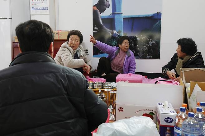 오영순, 김이선, 임화선 해녀가 마을 신당에 가져갈 음식을 싸고 있다.