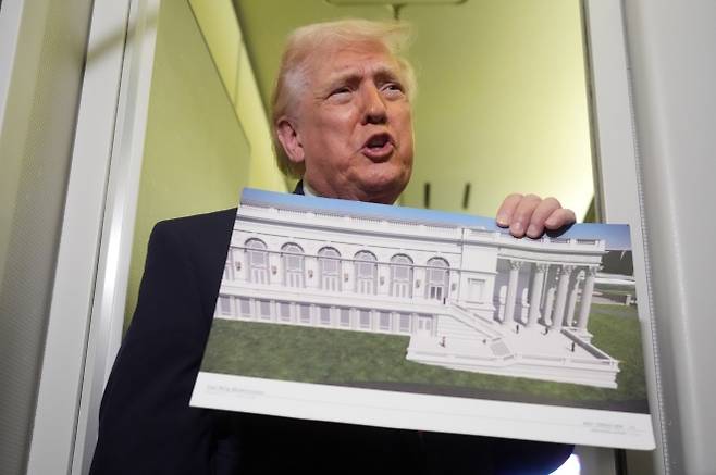 트럼프 “이란과의 휴전 빨리 타결 안 되면 이란의 모든 인프라 파괴” 위협 - 도널드 트럼프 미 대통령이 29일(현지시각) 플로리다주 웨스트 팜 비치에서 메릴랜드주 앤드류스 기지로 향하는 에어포스원에서 기자들과 연설하면서 백악관 새로운 이스트 윙 설계도를 들어보이고 있다. 그는 30일 이란과의 전쟁에서 휴전이 “빠른 시일 내에” 이루어지지 않으면 담수화 시설을 포함한 이란의 모든 민간 인프라들을 파괴할 것이라고 새로운 위협을 가했다. 2026.03.30. AP 뉴시스