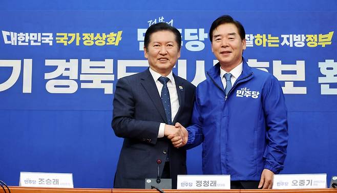 정청래 더불어민주당 대표가 1일 국회에서 열린 오중기 경북도지사 후보 환영식에서 오 후보에게 당 점퍼를 입혀준 뒤 기념 촬영을 하고 있다. 연합뉴스