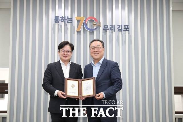 김병수 김포시장(왼쪽)이 지난달 30일 김포시청에서 시석중 경기신용보증재단 이사장으로부터 감사패를 받은 뒤 기념사진을 찍고 있다. /김포시