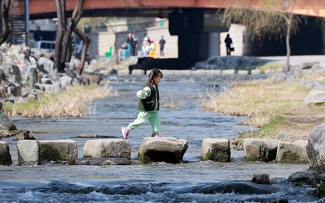 완연한 봄 날씨를 보인 지난달 23일 서울 종로구 청계천을 찾은 아이가 산책을 하고 있다. /뉴스1