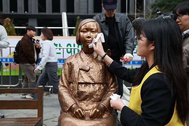 제1746차 일본군성노예제 문제해결을 위한 정기 수요시위가 1일 낮 서울 종로구 주한일본대사관 앞 평화로에서 열리기 전 평화의 소녀상을 둘러싸고 있던 경찰 울타리가 치워진 다음 한 정의기억연대 활동가가 소녀상 얼굴을 닦고 있다. 김혜윤 기자 unique@hani.co.kr