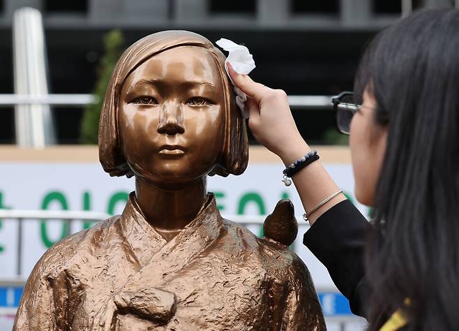 제1746차 일본군성노예제 문제해결을 위한 정기 수요시위가 서울 종로구 주한일본대사관 앞 평화로에서 열린 1일 낮 울타리에서 벗어난 평화의 소녀상을 한 정의기억연대 활동가가 닦아주고 있다. 김혜윤 기자 unique@hani.co.kr