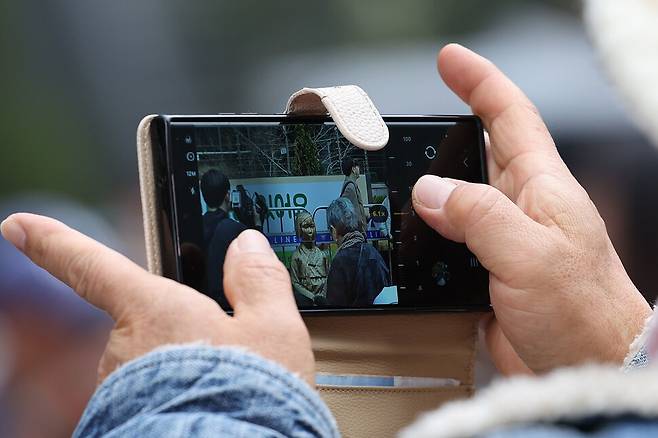 제1746차 일본군성노예제 문제해결을 위한 정기 수요시위가 서울 종로구 주한일본대사관 앞 평화로에서 열린 1일 낮 울타리에서 벗어난 평화의 소녀상을 한 참석자가 핸드폰에 담고 있다. 김혜윤 기자 unique@hani.co.kr