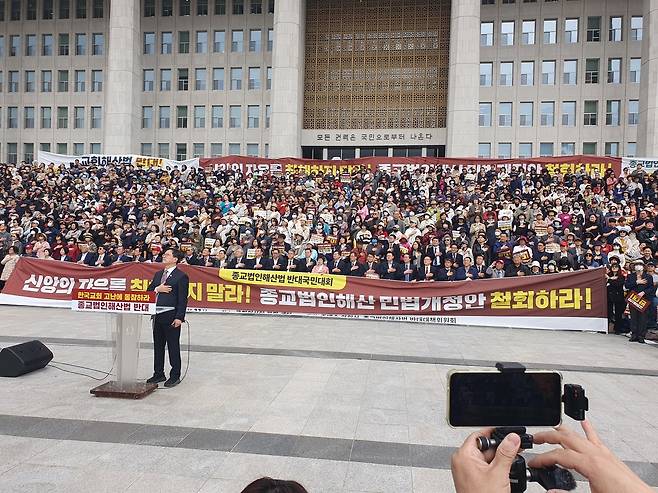 참석자들이 여의도 국회의사당 앞에서 집회에 앞서 국기에 대한 경례를 하고 있다.