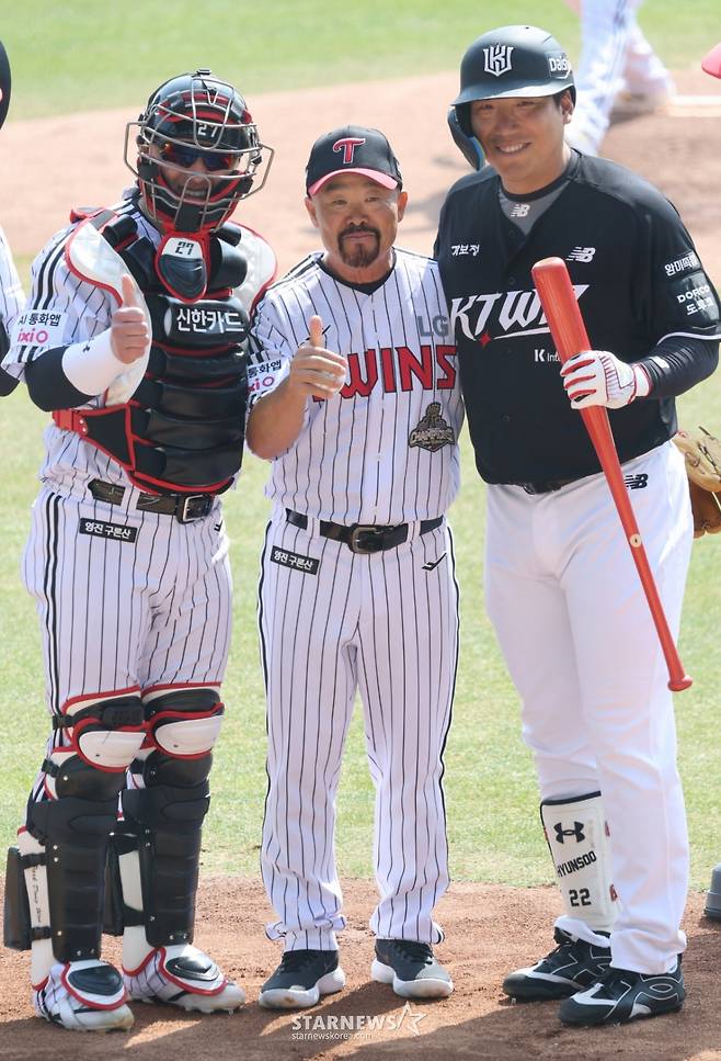 2026 신한 SOL Bank KBO리그 공식 개막전 LG 트윈스 대 KT 위즈 경기가 28일 서울 잠실야구장에서 열렸다.  LG 김용일 트레이닝 코치가 kt 김현수를 상대로 LG 승리기원 시구를 한 후 포수 박동원과 함께 기념촬영을 하고 있다. /사진=김진경 대기자