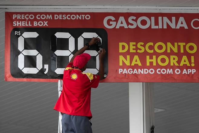 지난달 19일  지난달 19일 브라질 리우데자네이루의 한 주유소에서 직원이 휘발유 가격을 바꾸고 있다. [AP 연합뉴스 자료사진. 재판매 및 DB 금지]