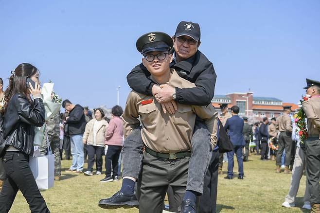▲ 2일 열린 해병신병 1327기 수료식에서 해병대 최초 4대 해병 가족이 된 김준영 이병이 2대 해병인 할아버지 김은일 옹을 업고 기념사진을 촬영한 모습. 해병대교육훈련단 제공