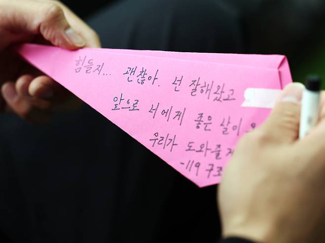 생명존중캠패인에 참여한 119 구조대원이 종이 비행기에 응원 메시지를 적고 있다.  뉴스1