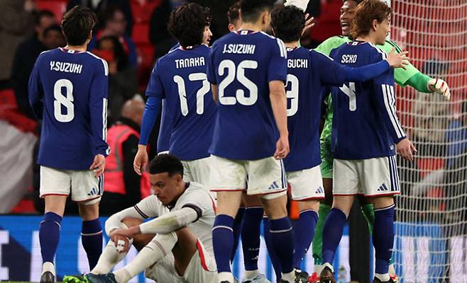 일본 “대어 잡았다”…망연자실한 잉글랜드 공격수  일본 축구대표팀 선수들이 지난 1일 잉글랜드를 1-0으로 꺾고 기뻐하는 가운데 잉글랜드 공격수 모건 로저스가 주저앉아 아쉬워하고 있다.  런던 | AFP연합뉴스