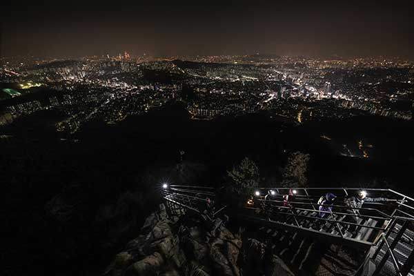 사당능선의 계단 뒤로 서울의 야경이 펼쳐진다.
