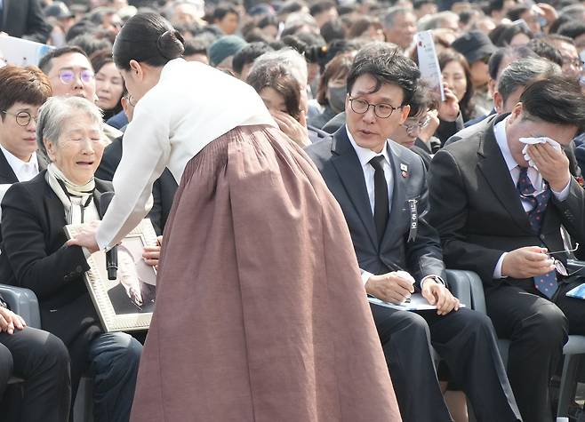 김미경 배우가 고계순 할머니에게 아버지 영정사진을 전달하고 있다. 우원식 국회의장(맨 오른쪽)이 눈물을 닦고 있다. / 사진=제주도