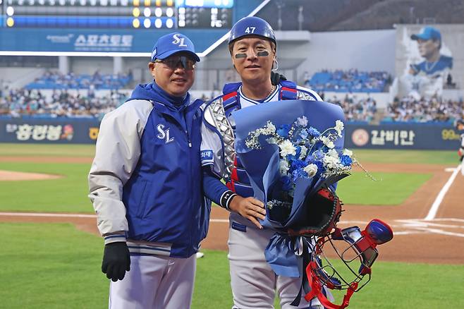 삼성 강민호(오른쪽)가 1일 대구삼성라이온즈파크에서 열린 2026 KBO리그 두산전에 출전하며 KBO리그 역대 최초 2500경기 출장 대기록을 달성한 후 박진만 감독과 기념촬영을 하고 있다. 사진 | 삼성 라이온즈