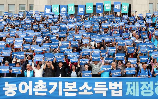 12일 오후 서울 여의도 국회 본청 앞 계단에서 열린 농어촌기본소득법 제정 촉구 기자회견에서 참가자들이 손피켓을 들고 구호를 외치고 있다. 2025.09.12 뉴시스