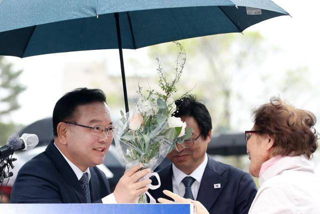 김부겸 전 국무총리가 3월 30일 오후 대구 중구 2·28기념중앙공원에서 6·3지방선거 대구시장 출마를 선언한 뒤 한 시민이 건넨 꽃다발을 받고 있다. 대구=뉴스1