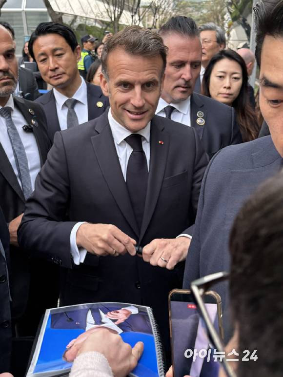 에마뉘엘 마크롱 프랑스 대통령이 3일 서울 여의도 한국경제인협회 회관에서 취재진의 요청에 사인을 하고 있다. [사진=권서아 기자]