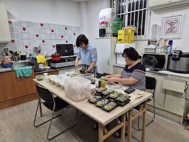 ‘너는 피투성이라도 살아 있으라’ 저자 임금주 함께하는교회 사모가 지난해 경기도 평택의 교회 은퇴 목회자와 목회자 남편과 사별 후 홀로 남은 사모를 섬기기 위해서 삼계탕과 밑반찬을 만들어 포장하는 장면. 임 사모 제공