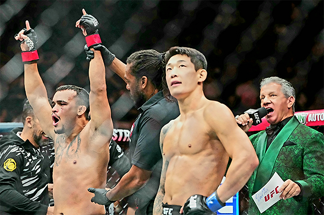 다니에우 구스타부 곤자가 산투스가 2025년 10월 미국 네바다주 패러다이스 티모바일 아레나 UFC 320 승리 선언을 들으며 감격하고 있다. 오른쪽은 UFC 데뷔 2연승 및 종합격투기 13연승 무산을 아쉬워하는 ‘좀비 주니어’ 유주상. 사진=Imagn Images=연합뉴스 제공