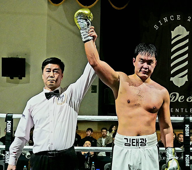 사단법인 한국복싱커미션 헤비급 챔피언 김태광이 2026년 3월 서울과학기술대학교 체육관 특설 링에서 주심 이현우로부터 7라운드 TKO 승리 및 타이틀 1차 방어 성공 선언을 받고 있다. 사진=KBM