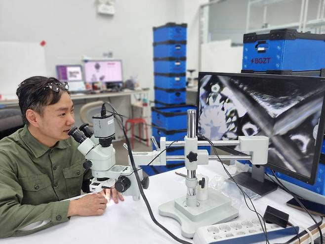 김재군 번개장터 검수센터 본부장이 최근 서울 성수동 번개장터 검수센터에서 헤럴드경제와 인터뷰를 하며 고배율 현미경으로 정·가품 여부를 확인하는 과정을 보여주고 있다. [번개장터 제공]
