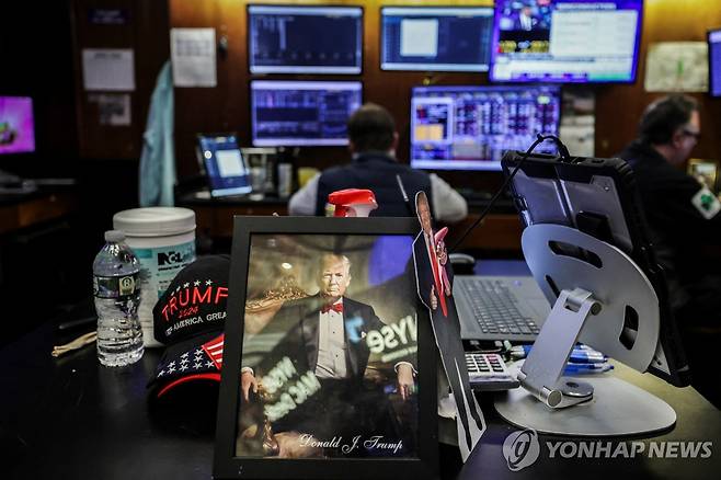 뉴욕증권거래소(NYSE)내 트레이더의 책상에 놓인 도널드 트럼프 미국 대통령의 초상 [로이터 연합뉴스 자료사진. 재판매 및 DB 금지]