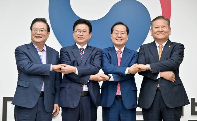 (왼쪽부터) 우동기 지방시대위원장 이철우 경북도지사, 홍준표 대구시장, 이상민 행안부 장관이 2024년 6월 대구경북 행정통합 관계 4대 기관 간담회에서 손을 맞잡고 있다. 경북도 제공