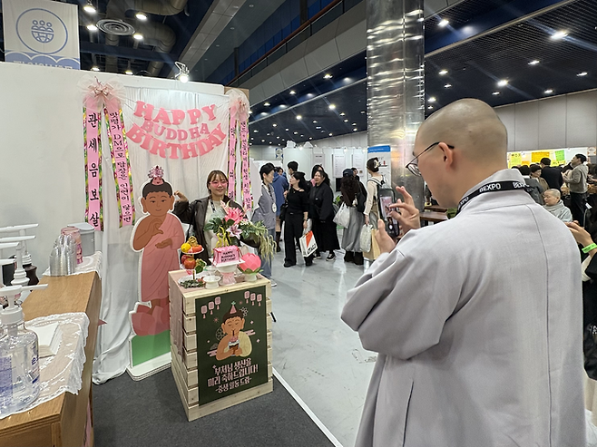 서울국제불교박람회의 부처님 생일카페 부스에서 스님이 방문객의 사진을 찍어주고 있다/사진=김지은 여행+ 기자