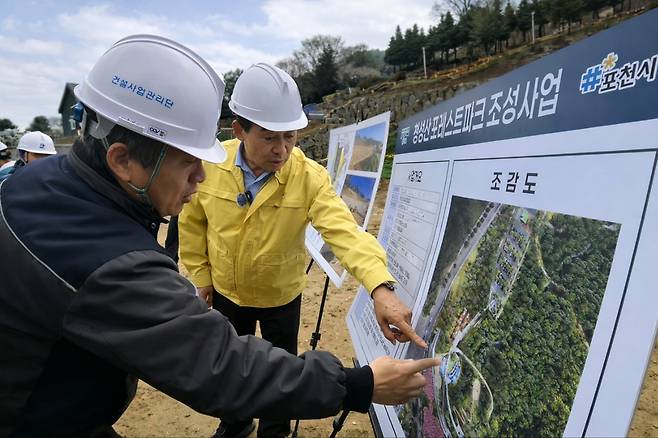 ▲ 백영현 포천시장(오른쪽)이 6일 오후 군내면 청성산 포레스트파크 조성 현장을 방문해 공사 관계자로부터 조감도를 보며 무장애 산책로 등 핵심 공정 이행 상황을 직접 점검하고 있다. /이광덕 기자 kdlee@incheonilbo.com
