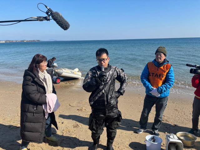잠수사 이사지 요시타카(가운데), '조세이 탄광 수몰 사고를 역사에 새기는 모임' 이노우에 요코(왼쪽) 대표와 우에다 게이시 사무국장이 2월 3일 일본 야마구치현 우베시 조세이 탄광 앞 해변에서 유해 발굴 잠수 작업을 앞두고 설명하고 있다. 우베=류호 특파원