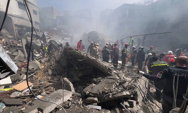 5일 이스라엘 보안군과 구조팀이 이스라엘 하이파에서 이란 미사일에 피격당한 주거용 건물 잔해를 해치며 야간 구조작업을 벌이고 있는 모습. AP연합뉴스