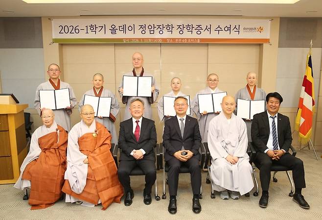 올데이골프그룹 최동호 회장(아래 왼쪽에서 세번째)이 김용현 동국대학교 교무부총장에게 장학금을 전달한 뒤 장학증서를 받은 학인 스님들과 함께 기념촬영을 하고 있다. 사진 | 동국대