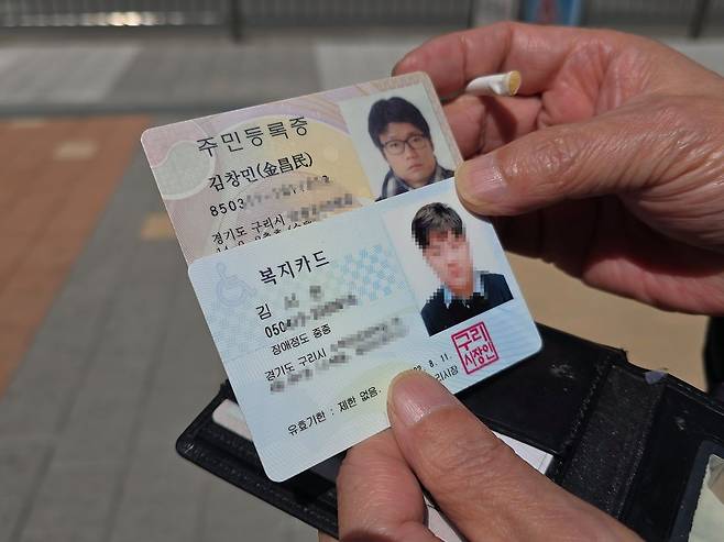 고 김창민 감독의 아버지 김상철씨가 지갑에서 김 감독의 주민등록증과 중증 자폐가 있는 손자의 복지카드를 들여다보고 있다. 손성배 기자