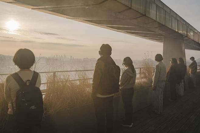 ‘리모트 서울’ 관객들이 강남 고층빌딩 꼭대기에서 인공지능 음성에 따라 도심을 바라보고 있다.    (c)GS아트센터