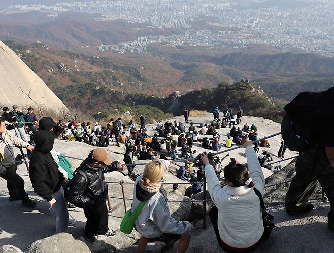 서울 북한산 백운대에 오른 등산객들이 북한산과 서울 시내를 바라보고 있다. [연합뉴스]