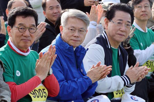 지난 5일 광주시 북구 전남대학교 종합운동장에서 열린 마라톤대회에서 더불어민주당 신정훈(왼쪽) 국회의원과 민형배, 김영록 전남광주통합시장 예비후보가 앉아있다. /연합뉴스